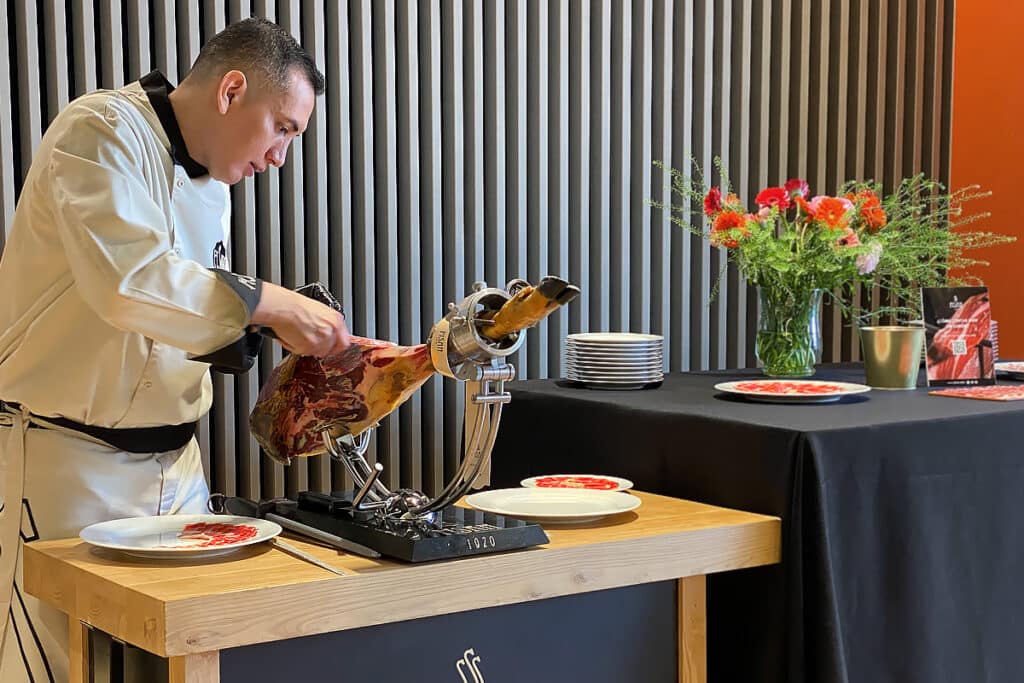 Cortador de jamón con Jamón de bellota ibérico en inauguración de la exposición “CUARENTAMÁSUNO” de #ESTILOVERINO