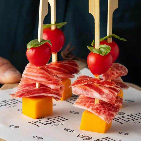 Brocheta de Jamón de Bellota con dados de cheddar madurado y aceite aromatizado de tomate seco