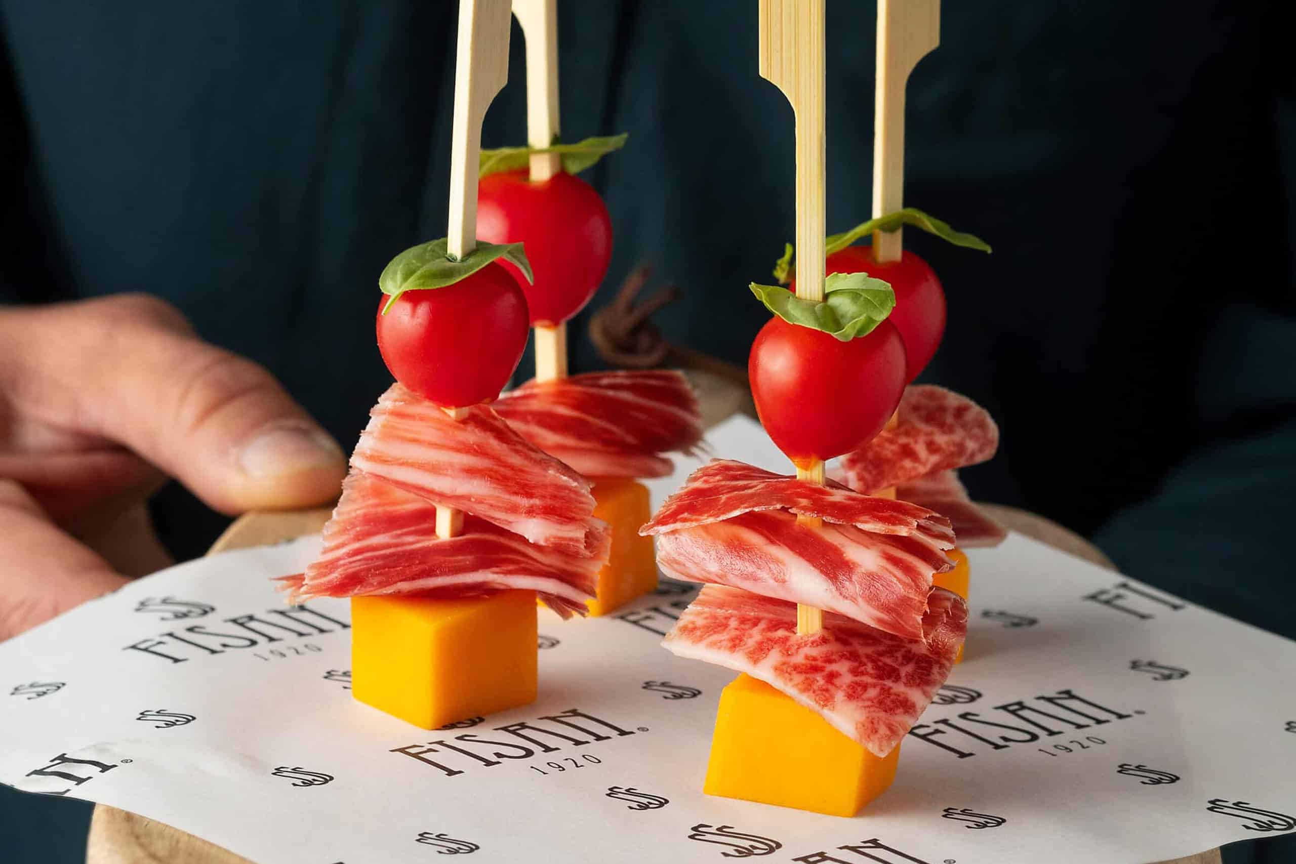 Brocheta de Jamón de Bellota con dados de cheddar madurado y aceite aromatizado de tomate seco