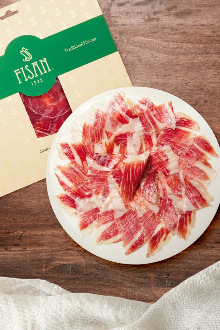 Plato de jamón ibérico FISAN loncheado, presentado sobre una mesa de madera