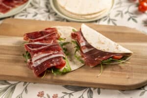 Wrap relleno de ibéricos FISAN con rúcula y tomatitos cherry, una alternativa moderna y nutritiva al bocadillo tradicional.